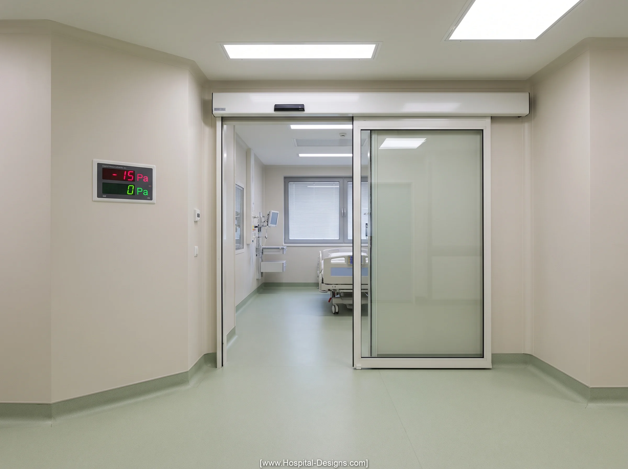 Hospital isolation room entrance with a sliding door and a wall-mounted differential pressure monitor.